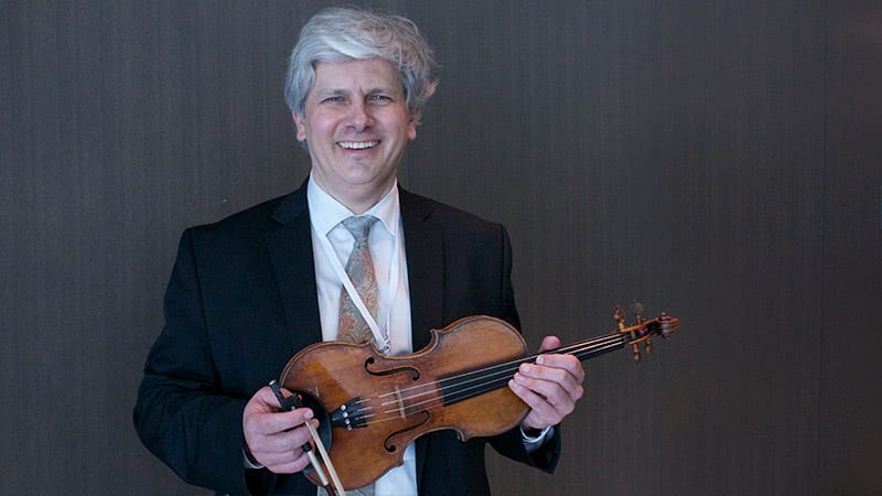 Nicholas Kitchen poses for a photo with his violin
